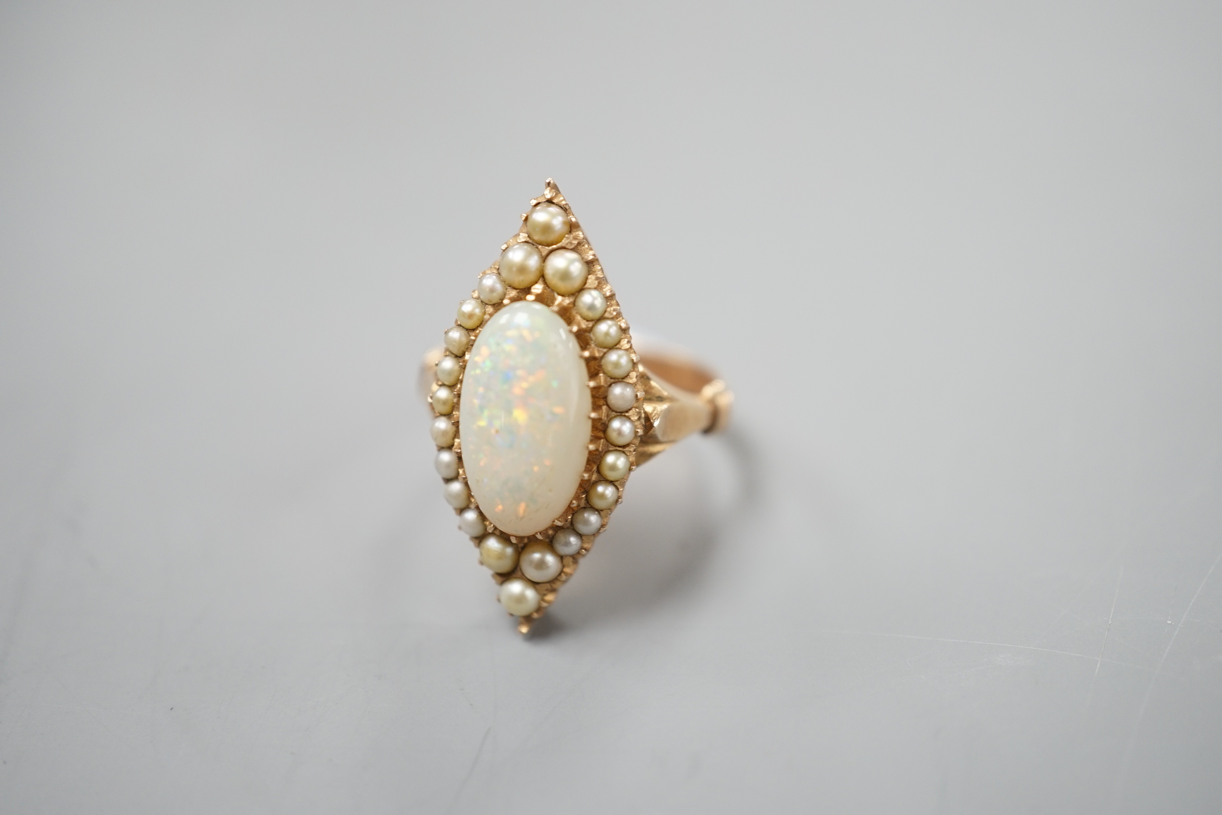 A yellow meat, white opal and seed pearl set marquise shaped cluster ring, size J/K, gross weight 5.6 grams.